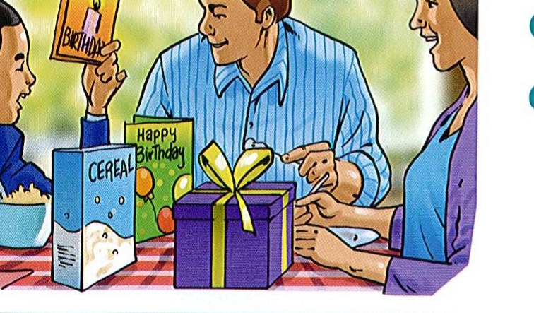 A boy has breakfast on his birthday with his parents and birthday cards